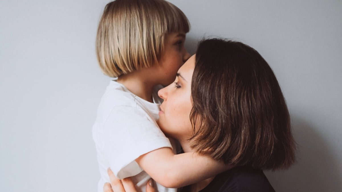 Mutter hält liebevoll die Hand ihres kleinen Sohnes – Symbol für emotionale Bindung und Erziehung